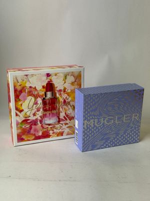 deux boîtes de parfum posées l'une à côté de l'autre sur une table