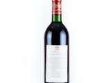 the bottle of wine is sitting on a white surface