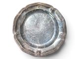 une assiette en argent posée sur une surface blanche