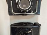 two cameras hanging on the wall next to each other