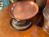 a copper plate sitting on top of a wooden table
