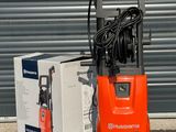 une pompe électrique orange posée à côté d'une boîte posée par terre