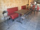 des tables et des chaises dans un restaurant, avec un mur en briques en arrière-plan