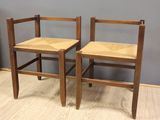 two wooden chairs sitting next to each other on top of a hard wood floor