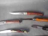 several different types of knives are lined up on a table