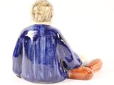 a figurine of a man sitting on the ground