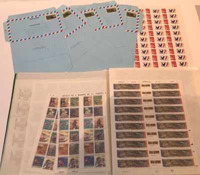 an open book with stamps and envelopes sitting on top of a table