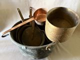 trois casseroles et deux cuillères posées dans un seau