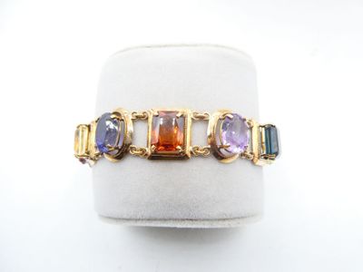 a close up of a gold ring with multi colored stones