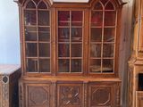 an image of a wooden china cabinet with glass doors in a room