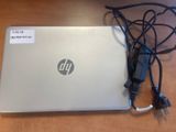 a laptop that is sitting on a table with a charger attached to it