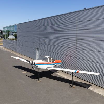 a small airplane that is parked in front of a building