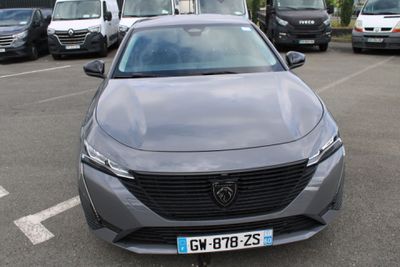 une voiture grise garée sur un parking, avec d'autres voitures en arrière-plan