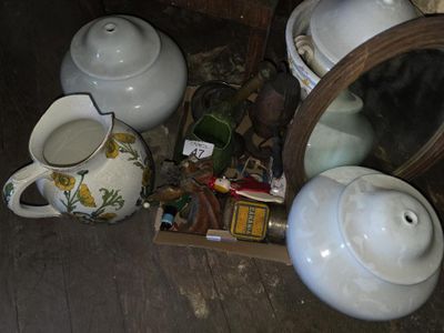 une théière et une autre théière posées par terre à côté d'un miroir