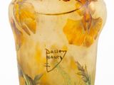 a glass vase with yellow flowers on it on a white surface