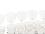 bottles and glasses are lined up on a tray on a white surface