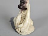 a figurine of a woman sitting on a shell
