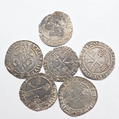 un groupe de cinq pièces d'argent sur une surface blanche