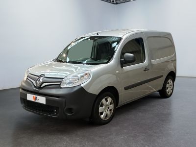 La camionnette grise est garée dans une pièce blanche au sol noir