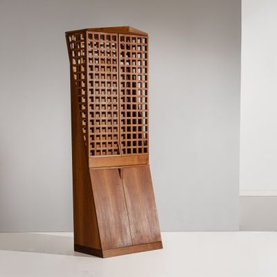 une grande armoire en bois munie d'une porte et d'un panier posé dessus