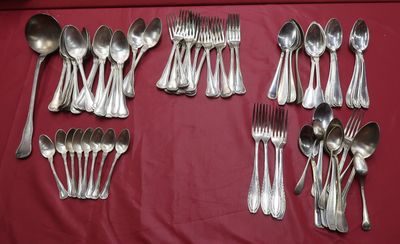 un grand nombre de cuillères et de fourchettes en argent disposées sur une table