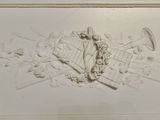 a relief of a man with a trumpet and a wreath on the wall