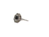 an image of a ring with a black stone surrounded by white diamonds