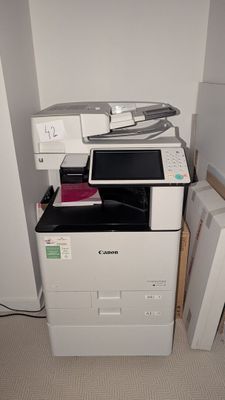 une imprimante blanche posée sur un meuble blanc