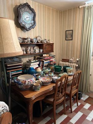 une salle à manger avec une table, des chaises et une horloge accrochée au mur