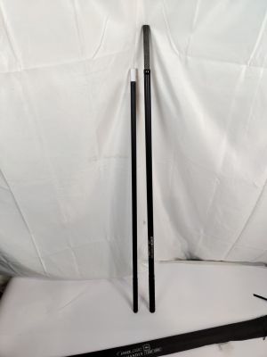 deux bâtons noirs posés sur un drap blanc, à côté d'un autre drap blanc
