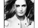 photographie en noir et blanc d'une femme aux cheveux longs portant une veste blanche