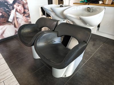 une photo d'un salon de coiffure avec deux fauteuils et un lavabo