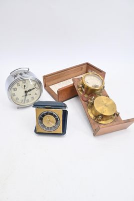 trois horloges et une boîte de pièces de monnaie posées sur une surface blanche