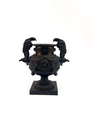 a black vase with two birds on it