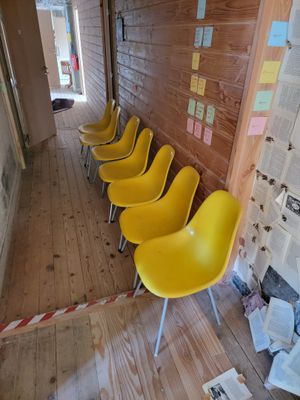 several yellow chairs are lined up against a wall in a room