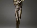 a bronze statue of a woman reading a book on a marble pedestal