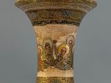 a gold vase with a picture of a group of people on it