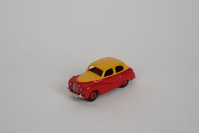 une petite voiture miniature posée sur une surface blanche
