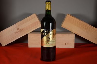a bottle of wine sitting on a table next to two wooden boxes
