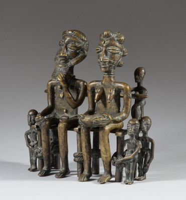a bronze statue of three people sitting on a bench