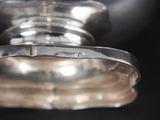 a close up of a silver object on a black surface