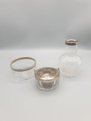 trois petits bocaux en verre avec des couvercles argentés, posés sur une surface blanche