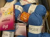 many balls of yarn in a box with a pair of scissors