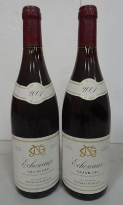 two bottles of wine sitting on top of a table next to each other