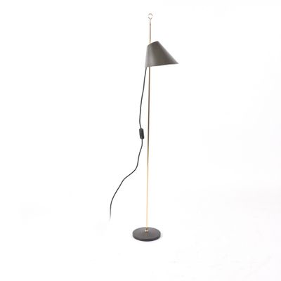 Le lampadaire est noir ; il est doté d'un pied en métal et d'un abat-jour noir.
