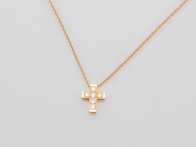 a gold cross necklace with diamonds on a white background