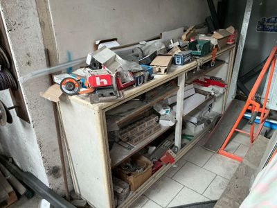 une photo d'un garage encombré avec des outils sur les étagères