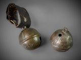 two old bells are sitting on a gray surface