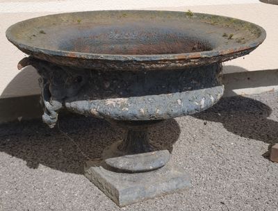 a rusted metal bowl sitting on the ground