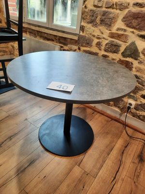 a table with a sign on it in front of a brick wall